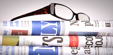 Newspapers with eyeglasses on top